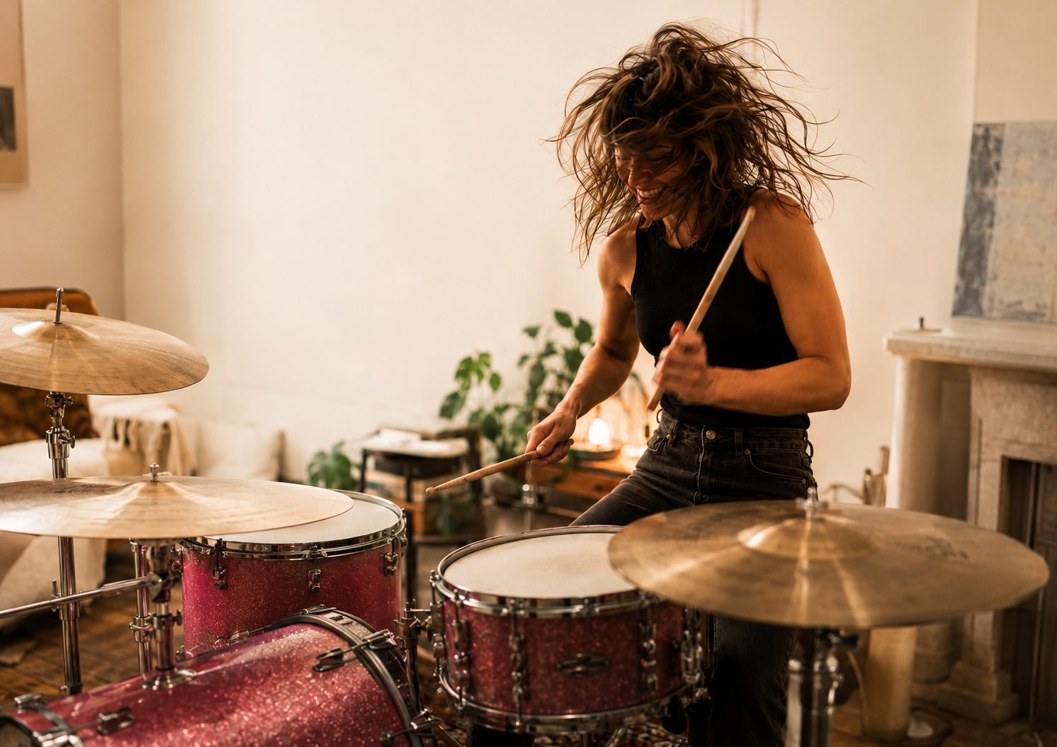 Adult beginner playing a pink drum kit in a relaxed studio setting